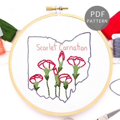 Red carnations stitched on white fabric inside the Ohio state outline.