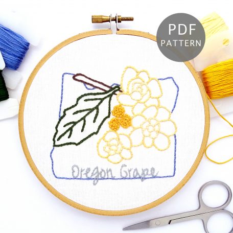 Oregon grape plant stitched on white fabric inside the Oregon state outline.