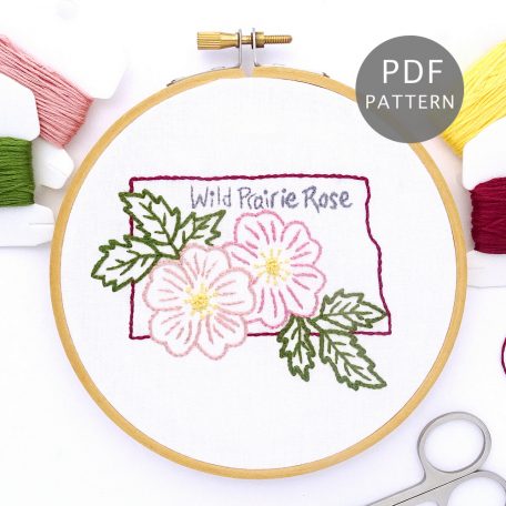 Pink Flowers stitched on white fabric inside the North Dakota state outline
