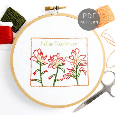 Indian Paintbrush flowers stitched on white fabric inside the Wyoming state outline
