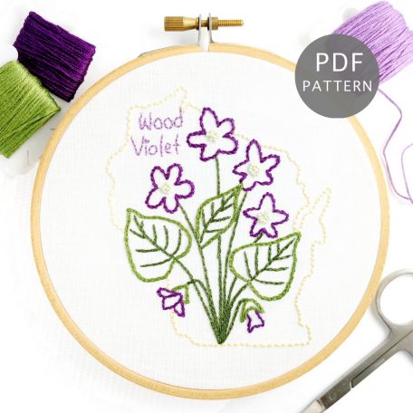 Wood Violet flower stitched on white fabric inside the Wisconin state outline.
