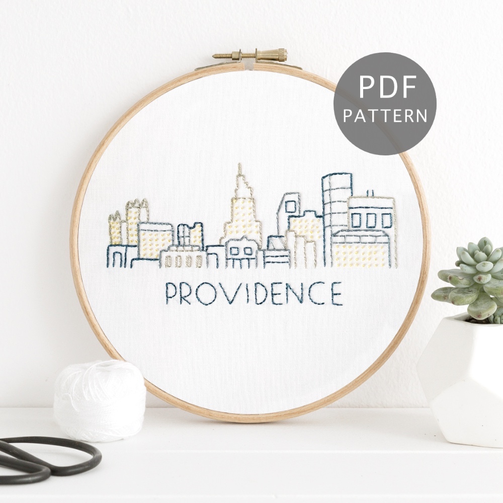 Providence skyline stitched on white fabric inside a wooden hoop