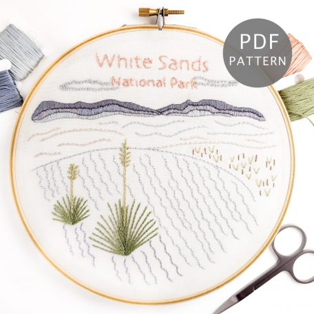 The White Sands National Park pattern stitched on white fabric inside a wooden hoop.